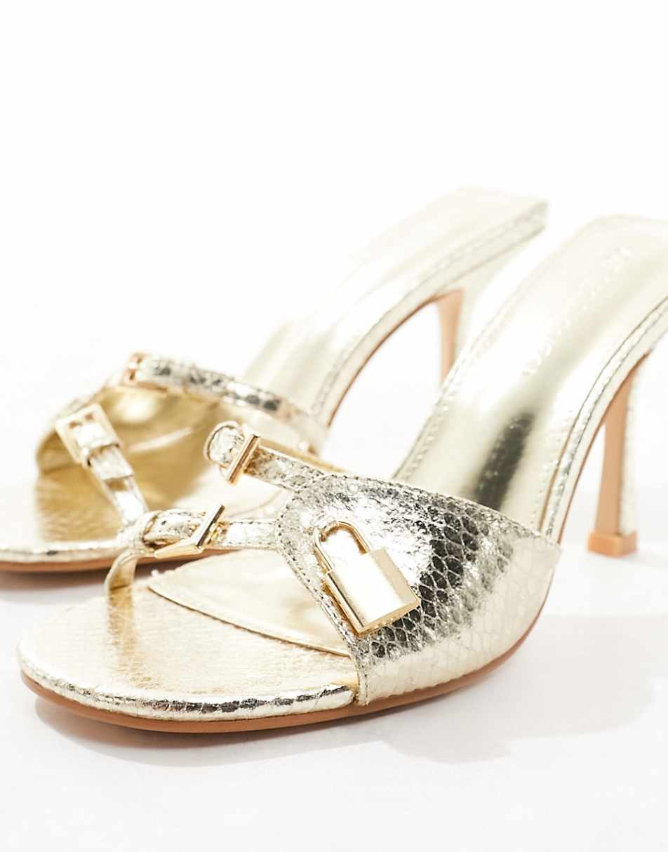 Public Desire Twisted heeled mules with padlock in gold snake