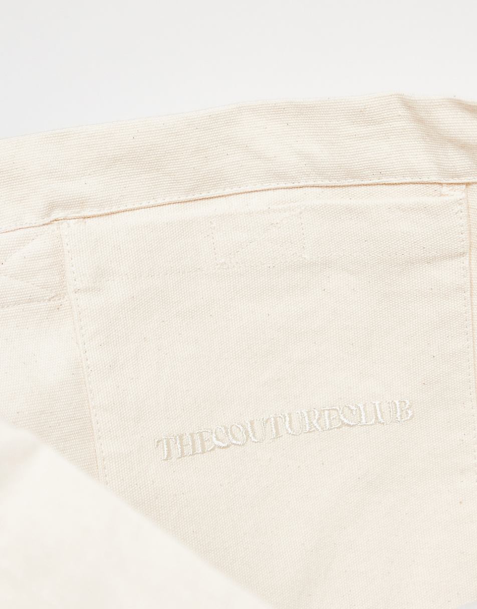 The Couture Club emblem logo tote bag in off white